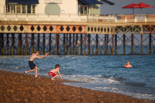 Children throw stones in the evening sunshine on Southsea beach on September 21, 2020 in Portsmouth. Picture: Finnbarr Webster