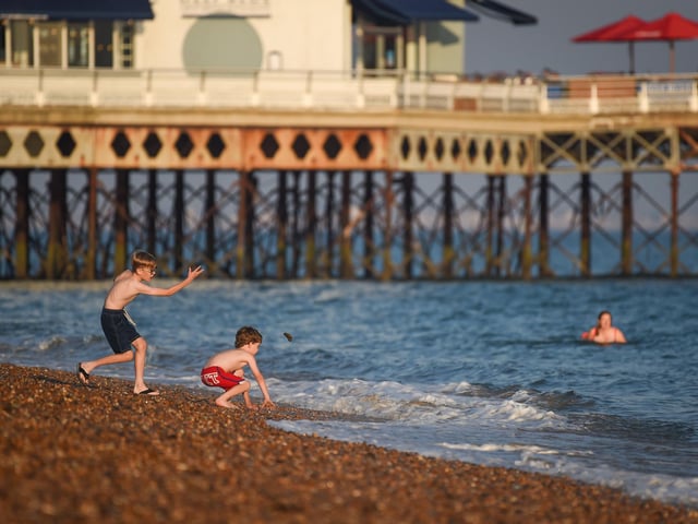 Children throw stones in the evening sunshine on Southsea beach on September 21, 2020 in Portsmouth. Picture: Finnbarr Webster