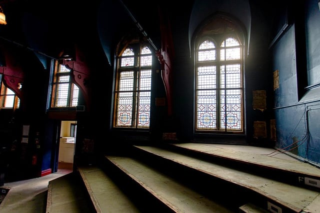 These stained glass windows in the auditorium have been have been hidden behind layers of insulation and wood for many years.