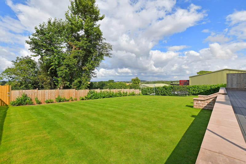 A sizeable garden which is mainly laid to lawn with two additional astro turf areas and hedge borders. From the garden, steps rise to a composite decked seating terrace, providing a space for outdoor seating.