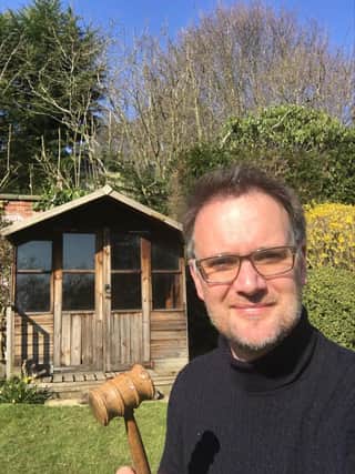 Charles Hanson with his gavel outside his garden shed.