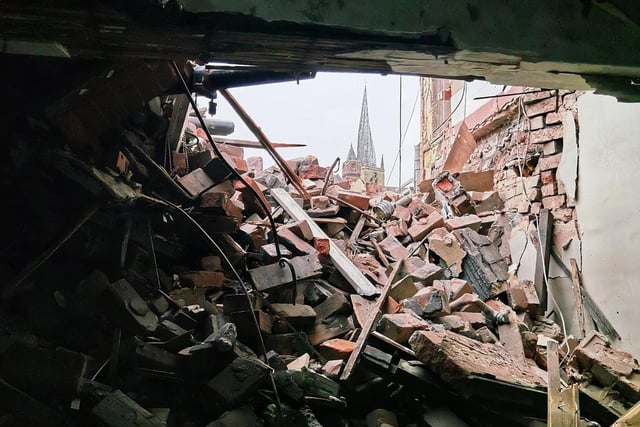 The Crooked Spire can be seen through the rubble.