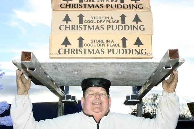 John Evans lifts 110 kilos of Christmas puddings on his head to set a record in 2016.