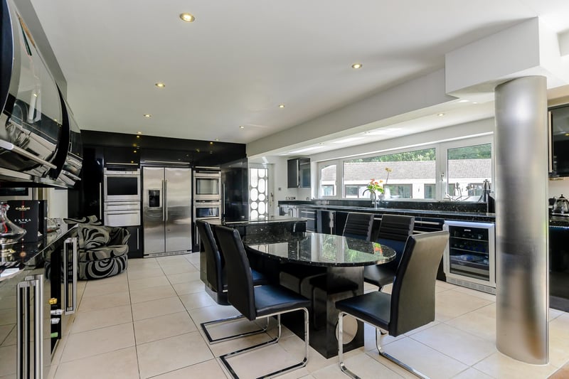 This stylish kitchen has a central island, wine cooler and inbuilt appliances