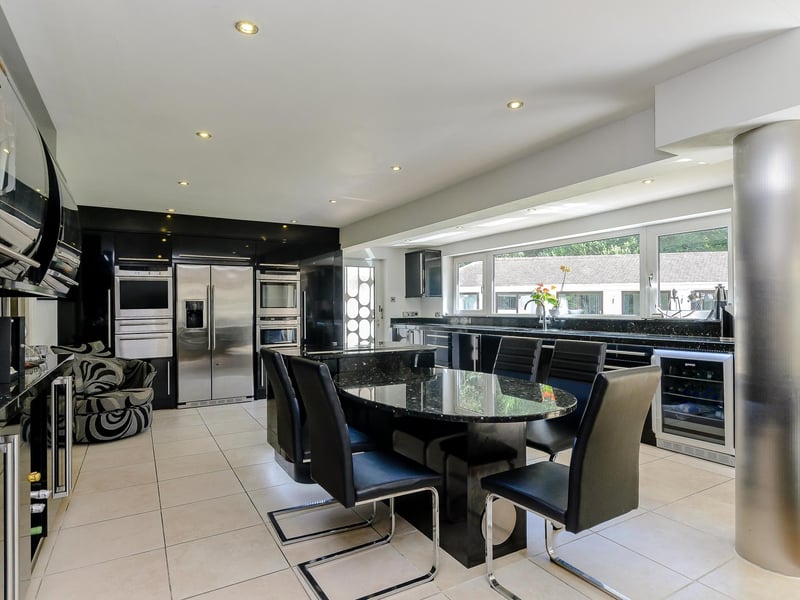 This stylish kitchen has a central island, wine cooler and inbuilt appliances