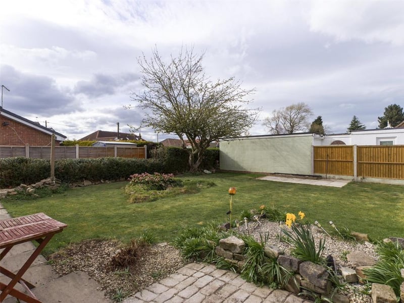 Enclosed rear garden laid to lawn with garden pond, plants and shrubs. tool shed and timer access gate.