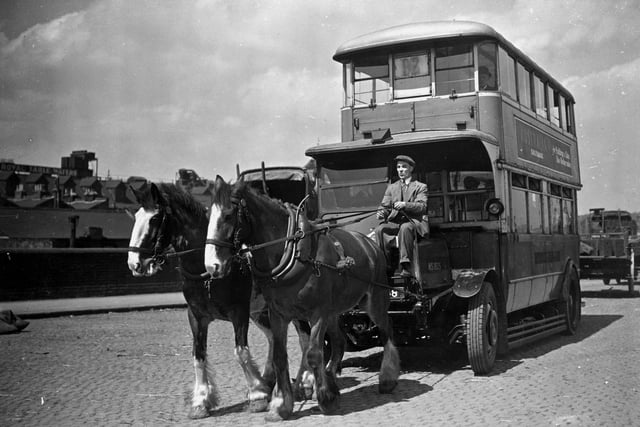 An old London bus being drawn by horses on its way to St Pancras Goods Station, London on May 26, 1937, where its roof was removed to enable it to fit on a railway trolley and taken to Chesterfield for breaking up.  (Photo by H. Allen/Topical Press Agency/Getty Images)