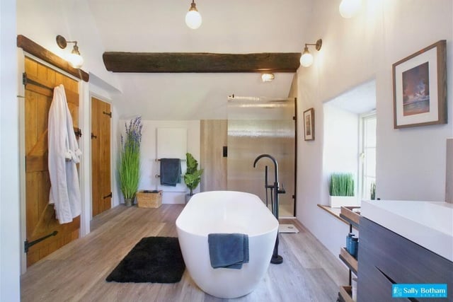 A freestanding bath in the middle of the room is a focal point of this modern bathroom which has a double width shower and original exposed beams to the ceiling. There is a large storage cupboard which is currently used as a walk-in wardrobe.
