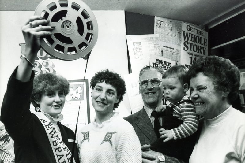 Exhibition hostess Karen Dale of Sheffield Newspapers shows a clip of a holiday film to visitors, left to right Mrs Marilyn Eddison, her young son Robert and his grandparents Mr and Mrs Kemp, January 1983
