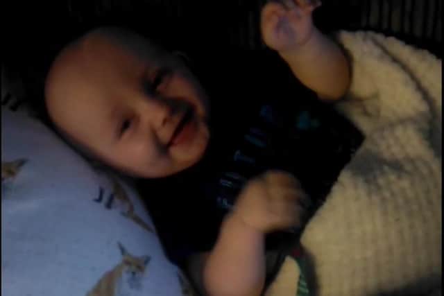 Video clip shows the infant laughing and giggling as an adult plays with a cuddly toy on October 25