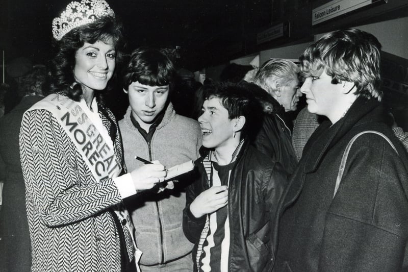 Miss Great Britain Jill Saxby signs autographs for admiring young fans at the 1985 holiday and travel exhibition