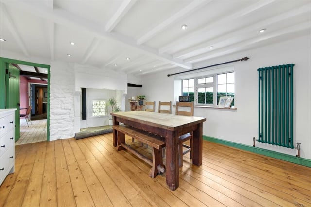 Polished pine floorboards, painted exposed beams to the ceiling and a fire opening with raised stone hearth and heavy cobbled lintel are focal points of this room. The rear windows overlook the gardens and open countryside beyond.
