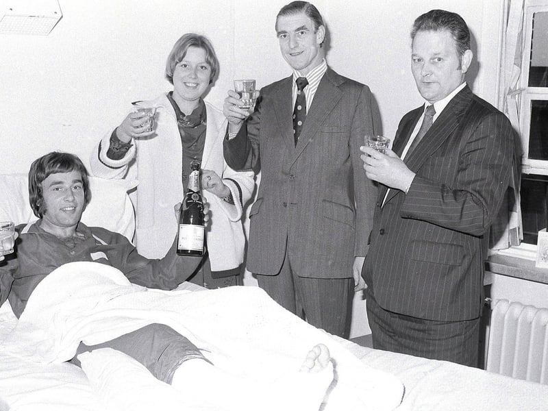 Barry Foster celebrates promotion in his hospital bed after breaking his leg .