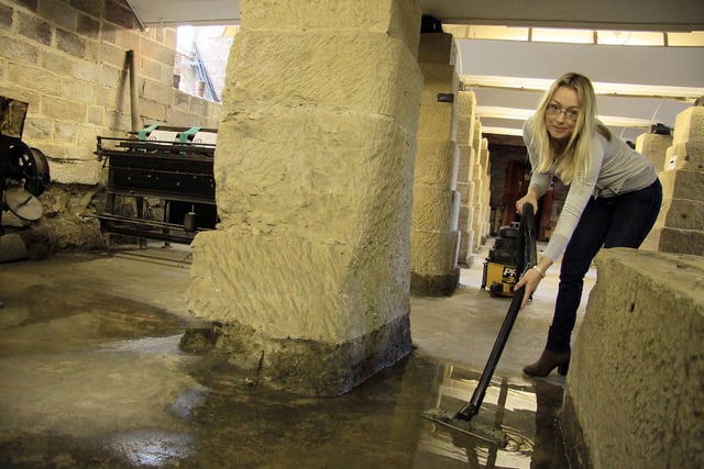 Natasha Wintersinger manager at Strutts North Mill, Belper, cleaning up flood water in the basement, in 2012.