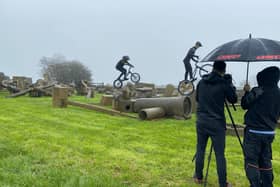 BBC's Owen Shipton is kept dry by Carl a Weightman as he films Oliver and Eddie Weightman