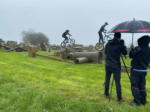 BBC's Owen Shipton is kept dry by Carl a Weightman as he films Oliver and Eddie Weightman