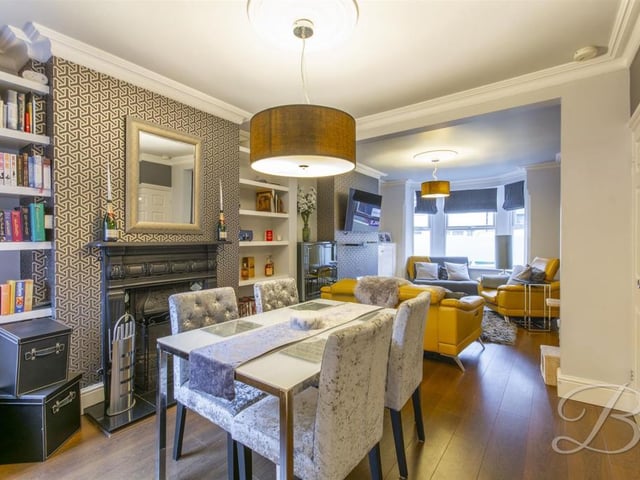 Feature fireplace, laminate flooring, central heating radiator and window to rear elevation.