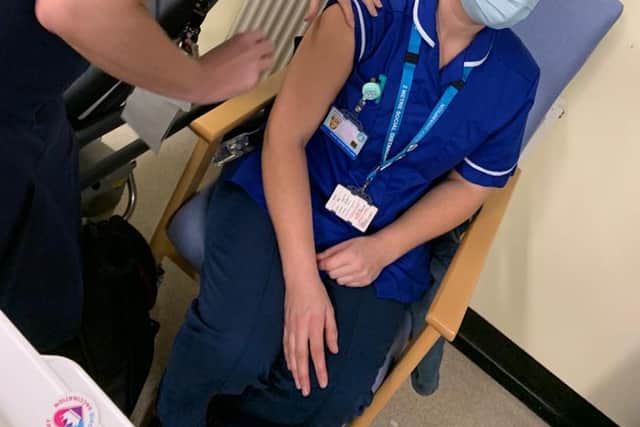 Chesterfield Royal Hospital's Stacey Burton delivers the 10,000th jab to Amy Chapman from the Community Nursing Team at Alfreton Primary  Care.