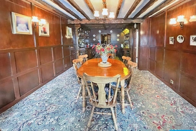 The wooden panelled dining room has exposed ceiling beams.