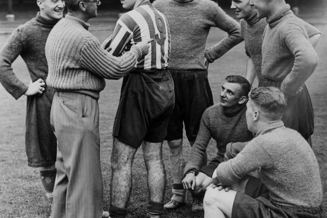 The trainer for Chesterfield Football Club, Mr Day shows off the new number on the shirt of the club's center-forward, Mr Milligan. Numbers on shirts were introduced for the start of the planned 1939/40 season to make it easier for spectators to recognise them.