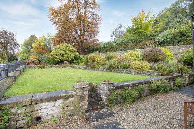 The garden's borders feature an array of trees and shrubs and there are views towards Bakewell. There is also a paved seating area and timber storage sheds.