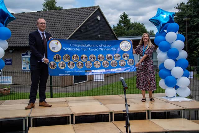 Headteacher Mark Parkinson pictured next to Abi Mayfield, communication and engagement manager at Flying High Trust, with a banner of winners