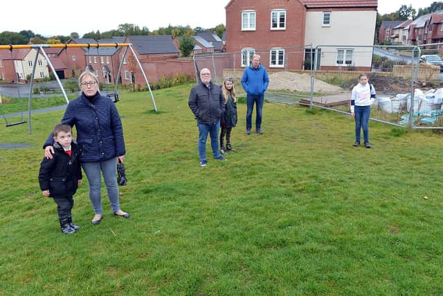 Residents say their children's play area on a new Chesterfield housing estate is 'dangerous'. Those pictured include Andy Woodward and Ruby Davenport, Phil Bradley and Emily Smalley.