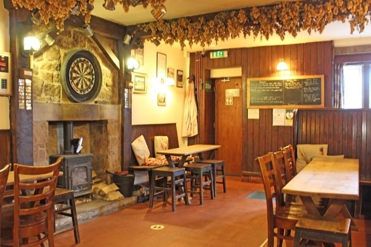 A log burning stove in a stone hearth and wooden panelling on the walls provide a cosy environment for diners and drinkers.