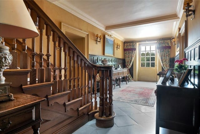 A stunning carved wood staircase leads from the characterful entrance hall.