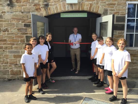 (L-R) Tyrell Samuels, Luca Webster, Ellie Robinson, Macie Nightingale, headteacher Dr Mike Bywaters, Arlo Tye, Callum Styles, Rhiannon Bailey-Evans, Imogen Wall opening the newly refurbished pool at Highfield Hall Primary School
