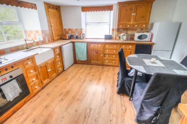The dining kitchen contains an inset Belfast sink, fitted base units incorporating cupboards and drawers with work surfaces over and matching wall mounted cupboards. There is a gas hob with cooker hood and built-in oven.