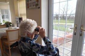 Residents of the care home are a picture of concentration and joy with binoculars in hand.