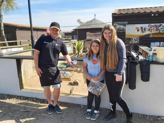 Millie (centre) and cousin Chloe with volunteer director David Taylor outside the meerkats' enclosure at Willow Tree Family Farm in Shirebrook.
