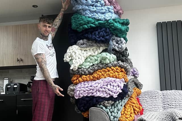 Dan Soar with the mountain of blankets he knitted in 24 hours.
