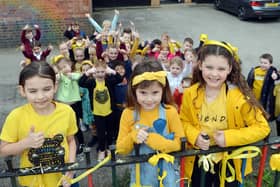 Tibshelf Infant and Nursery School children and parents tie ribbons on the school fence as part of the national day of reflection to mark one year since the first lockdown.