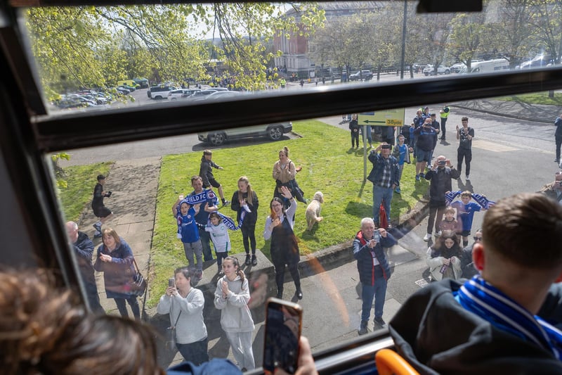 Fans cheer the bus as it goes past