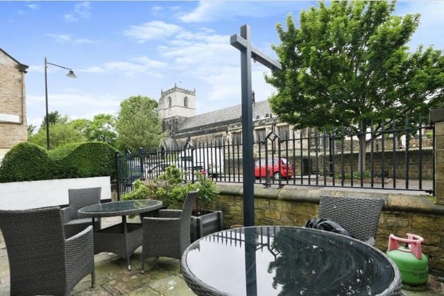 A courtyard style seating area at the front of the house looks across the road to St John Baptist Church.