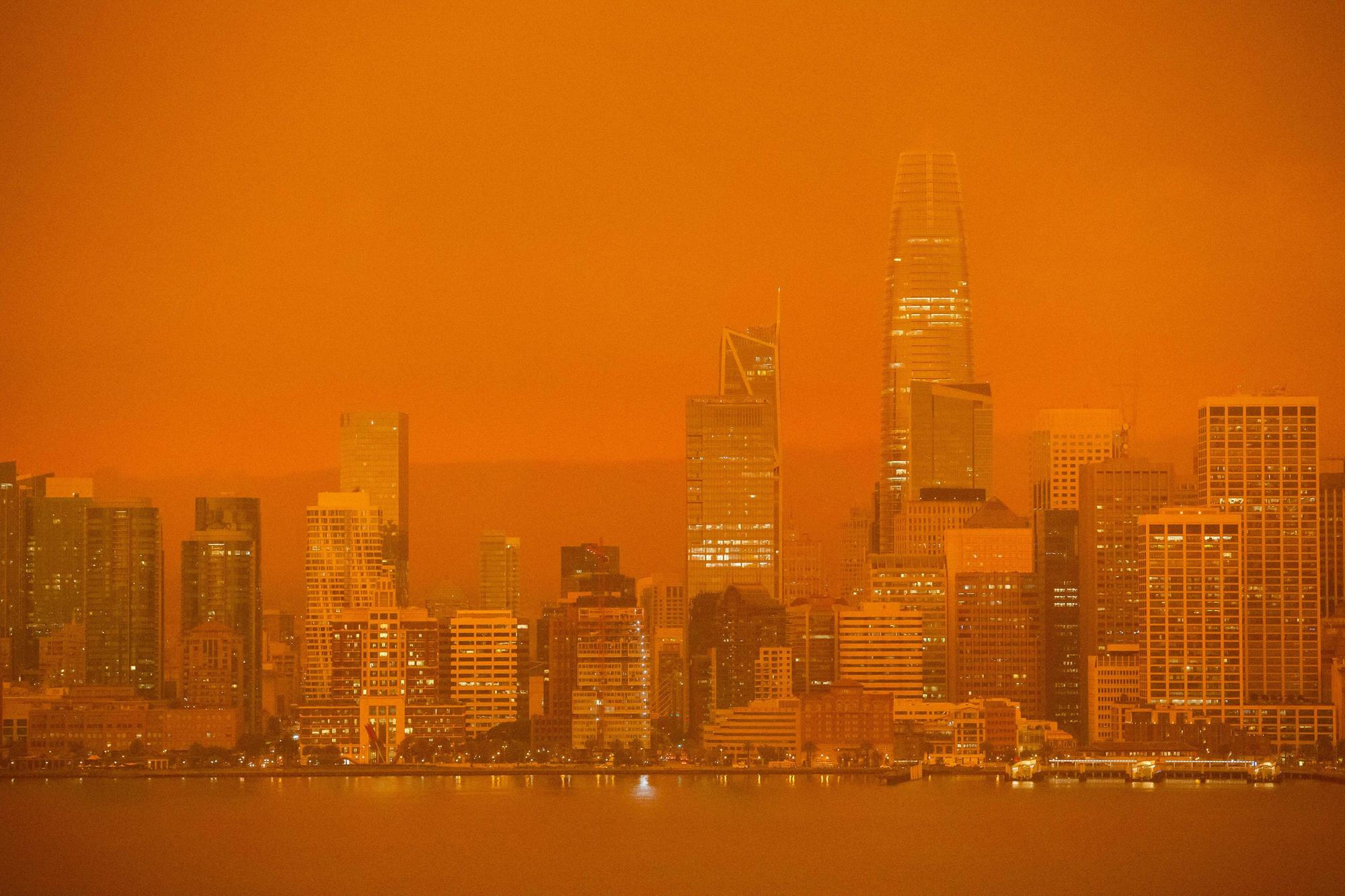 The San Francisco skyline is obscured in orange smoke.