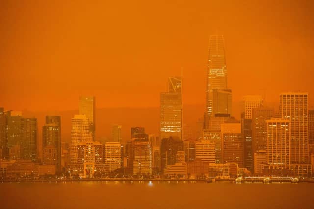The San Francisco skyline is obscured in orange smoke.