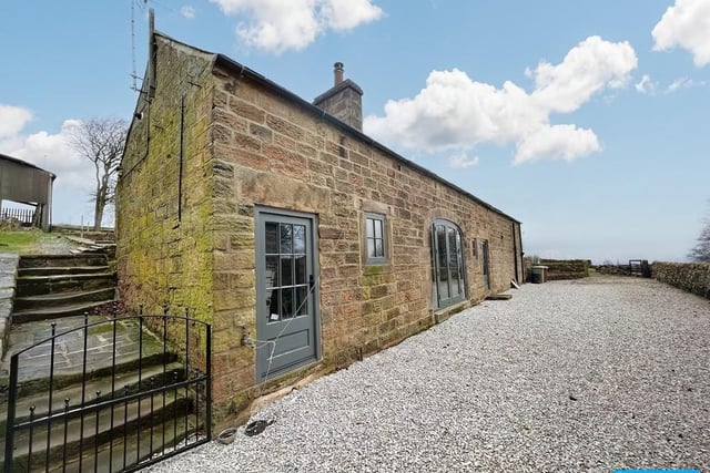 The detached, converted former coach house is built from stone.