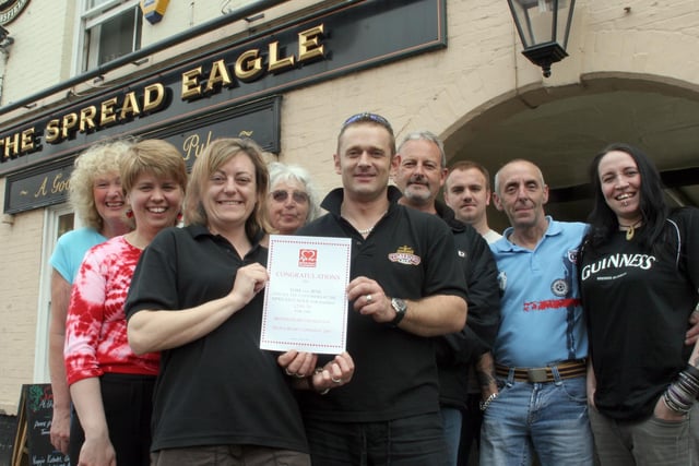 Tom and Jenni Symons, landlord and landlady of Chesterfield's Spread Eagle pub in 2007, raised  £389.39  for British Heart Foundation and are pictured with female representatives of the charity and several of the pub's regulars.
