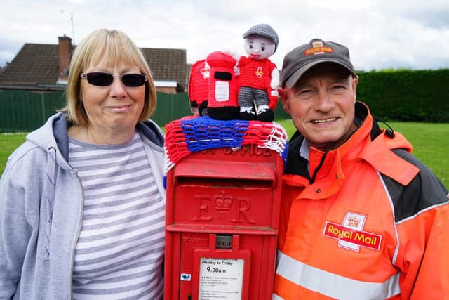 Retiring North Wingfield postman Phil Jeffery with Joan Stanley who knitted the the yarn at the Little Morton Road post box.