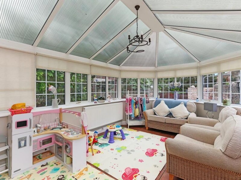 The sun room opens out to a paved patio area.