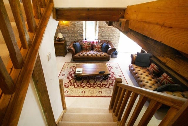 The spacious sitting room contains an alcove where there is a feature original mill shaft. Exposed ceiling beams emphasise the origins of this lovely home.