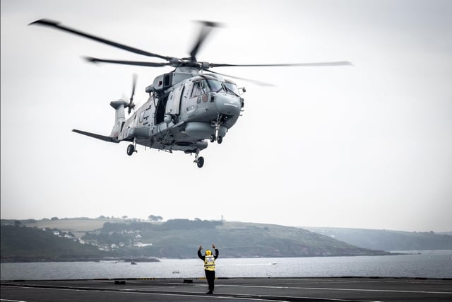 A Merlin helicopter conducts training with HMS Queen Elizabeth while anchored just off Plymouth Sound. This image won the Royal Navy Amateur Maritime Image Award. By AB Bill Spurr