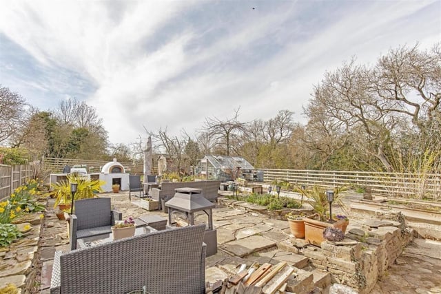 The rear garden contains a stone flagged patio with pizza oven and barbecue area.
