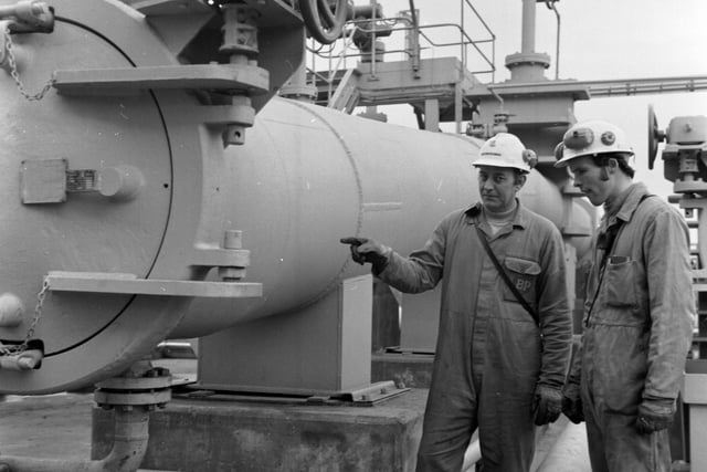 The BP complex at Kinneil on the Firth of Forth, end of the  384km crude oil pipeline from the Forties oilfield in the North Sea, November 1975. Alex Erskine pointing to the end of the pipe.
