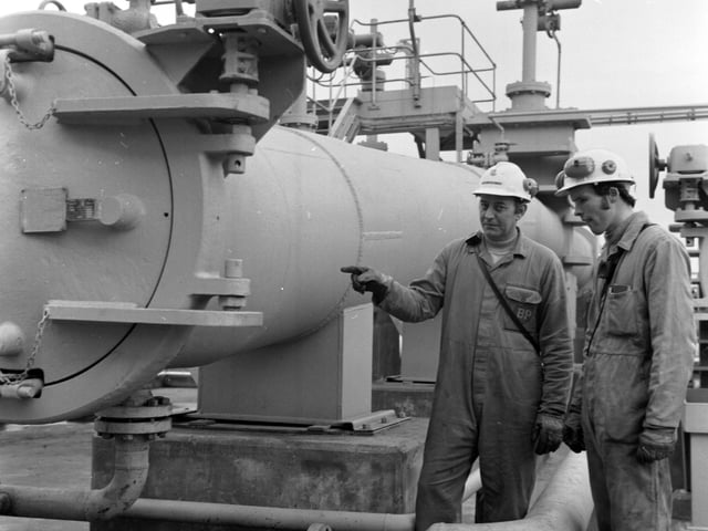 The BP complex at Kinneil on the Firth of Forth, end of the 384km crude oil pipeline from the Forties oilfield in the North Sea, November 1975. Alex Erskine pointing to the end of the pipe.