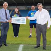 John Croot, chief executive of Chesterfield FC Community Trust, receives a cheque from Derbyshire PCC Hardyal Dhindsa, watched by Community Trust staff. Photo: Tina Jenner.
