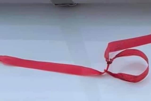 The red ribbons look like this and have been tied on peoples' gates.